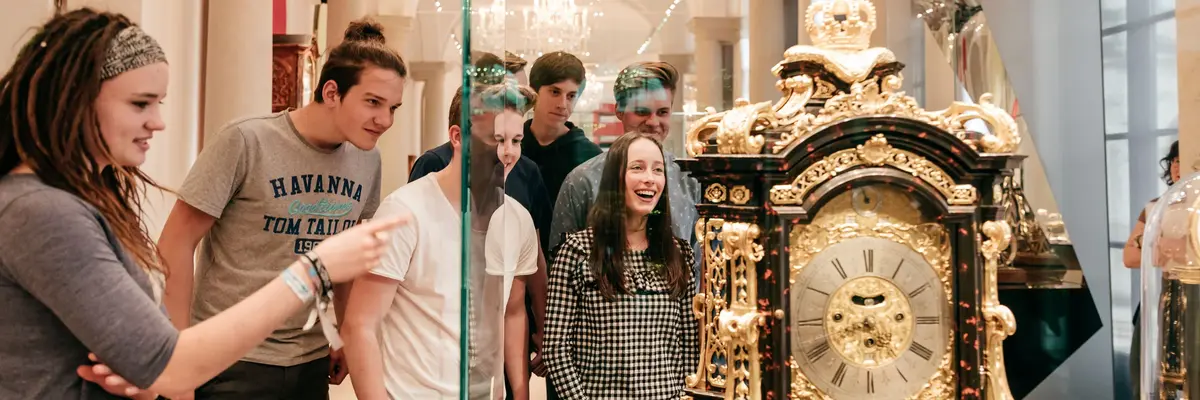 Eine Gruppe von Jugendlichen steht vor einem Museumsexponat
