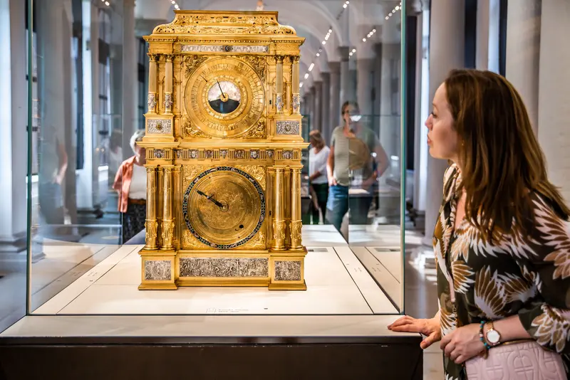 Frau schaut sich goldene Uhr an